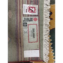 Late 20th century Louis De Poortere Belgian Shalamar wool ground rug, featuring a vibrant multi-coloured geometric design with stacked rectangular borders surrounding two central medallions, finished with fringed ends