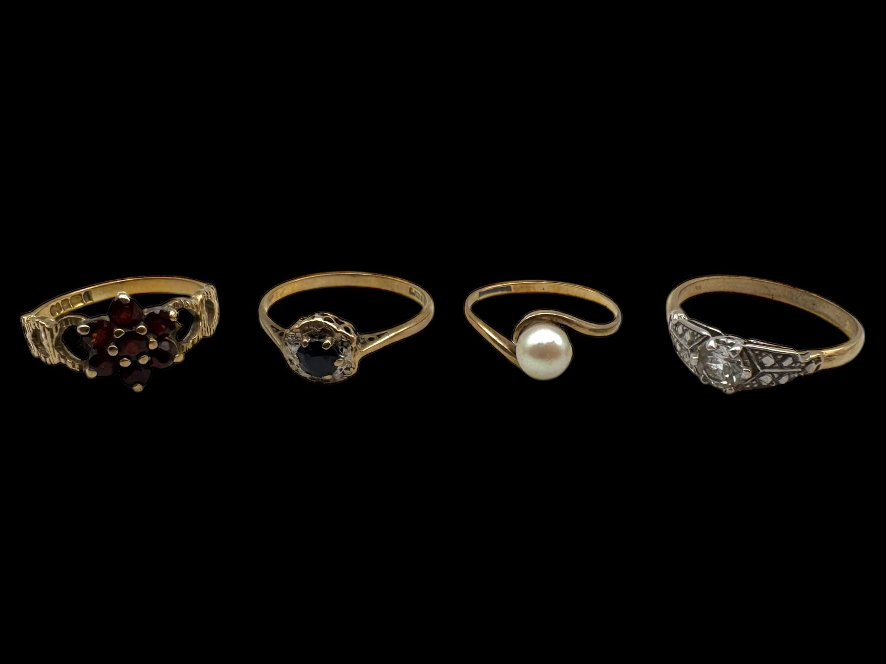 Four 9ct gold stone set rings, including garnet and pearl examples, all stamped or hallmarked