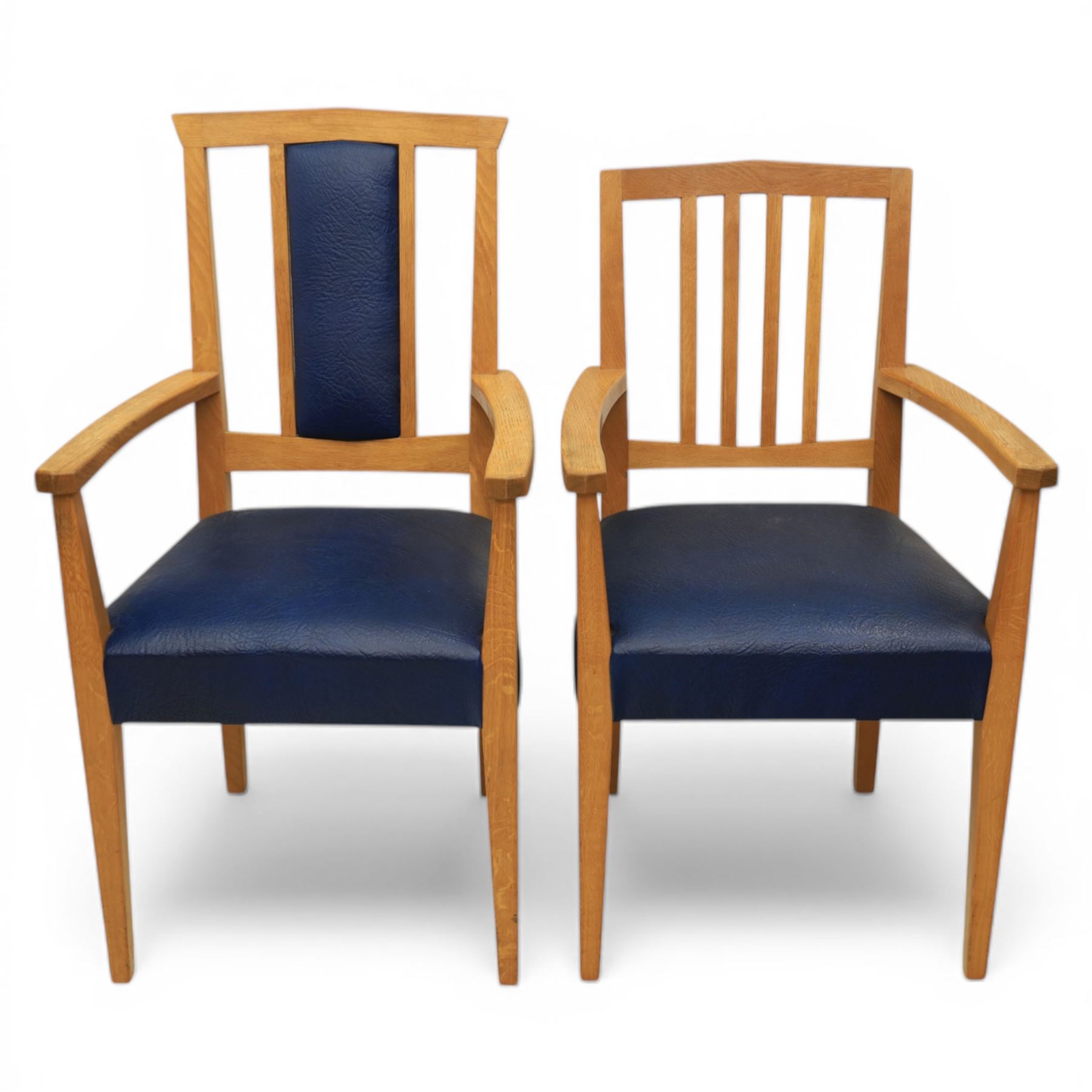 Modern twelve oak dining chairs including one 'Chairmans' chair, solid oak construction, slatted back and arm rests, blue leatherette padded seat, on tapered square supports 