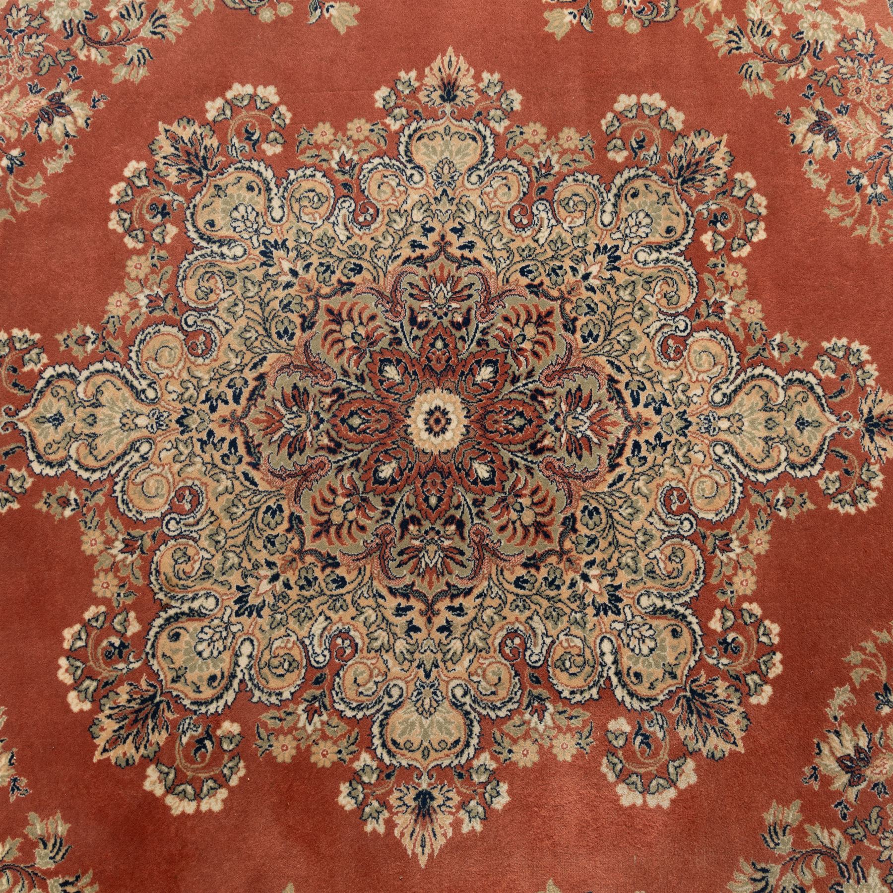 Persian Kashan rug, the rich terracotta field with central floral medallion and palmette spandrels, surrounded by a cream border of stylised boteh and foliate decoration