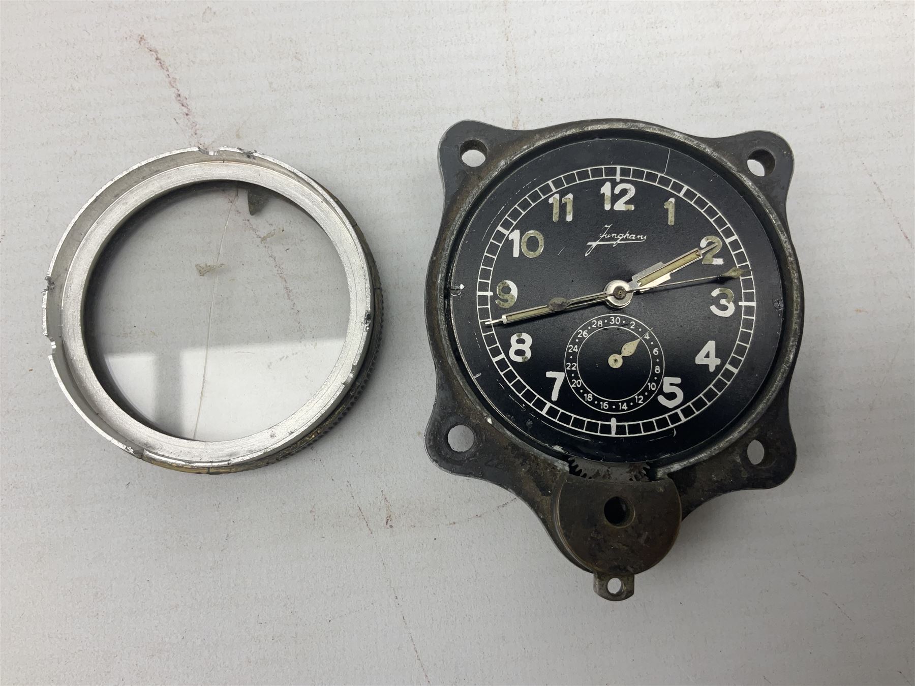 WW2 Jungans Luftwaffe aircraft cockpit clock with luminous centre sweep seconds hand, baton hour and minute hands, regulation 45mm black dial with date recorder, formerly illuminous Arabic numbers and minute track, rotating bezel (seized), going barrel movement with a lever escapement serial No 22901 jewelled to the centre wheel, over-sprung balance with timing  screws, max.H8cm