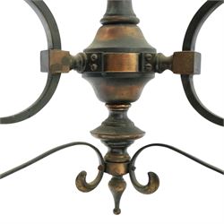 Art Nouveau copper three branch chandelier, turned central column with foiliate collar, issuing three scrolling strapwork arms, fitted with cut glass pendant shades, suspended from a chain
