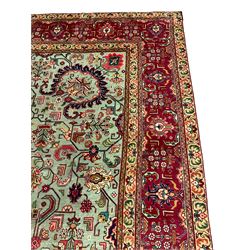 North West Persian Tabriz carpet, pastel green ground field with shaped pole medallion, surrounded by interlacing branch and stylised flower head motifs, red ground border decorated with plant motifs