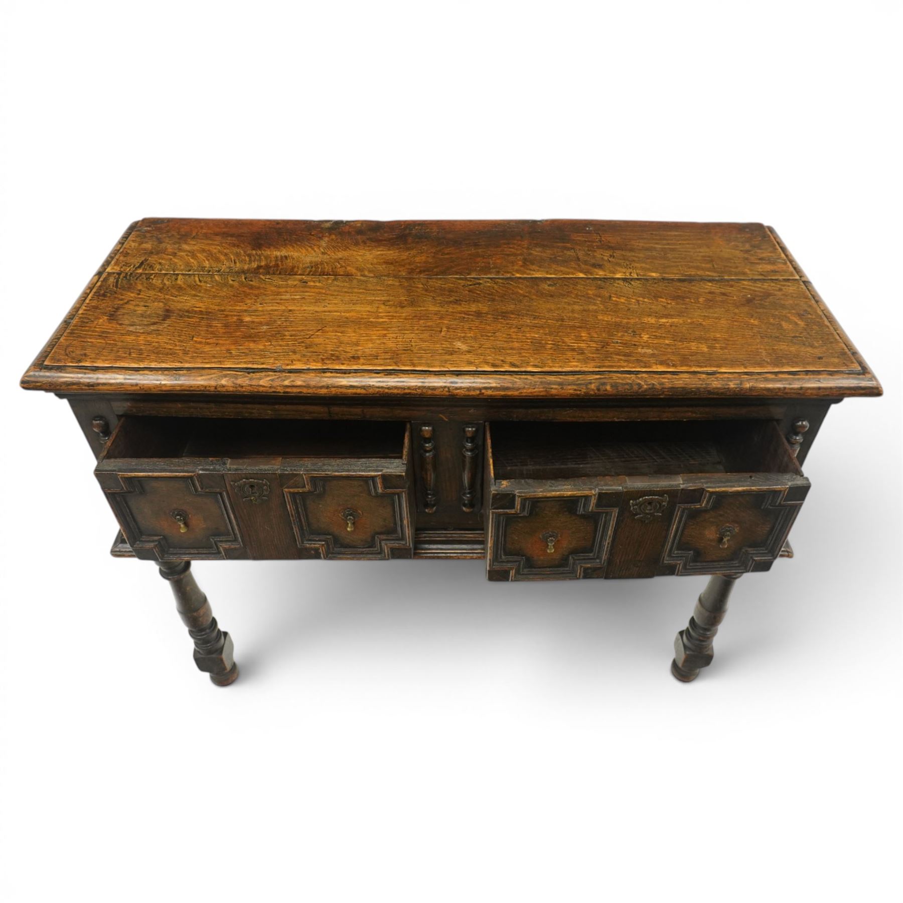 Georgian oak dresser base, plank top above an arrangement of two fielded panel drawers with moulded geometric fronts, on turned front supports and block rear legs