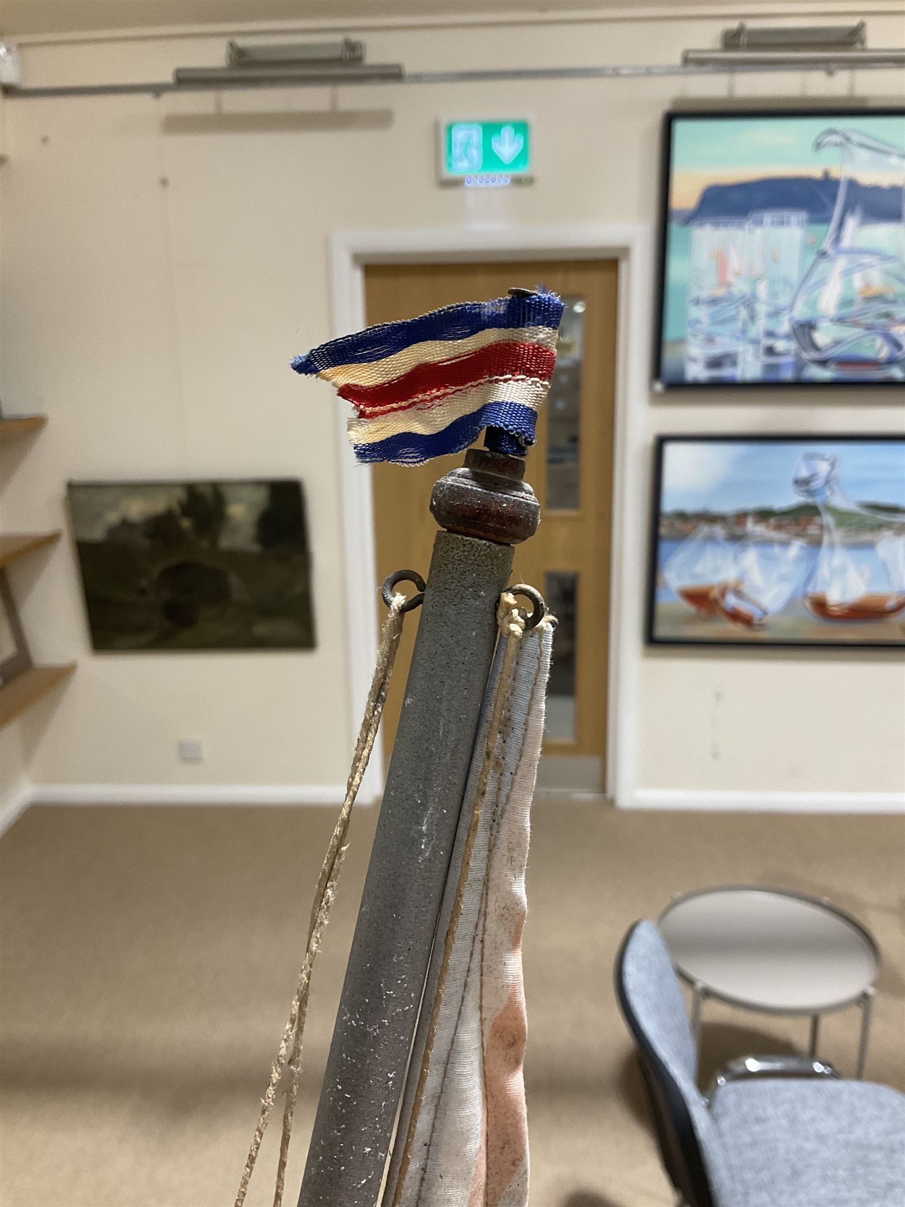 Large pond yacht with simulated planked mahogany deck, mahogany hull, wooden keel and stern fin and tubular aluminium mast with two sails; on wooden stand L131cm H on stand 177cm