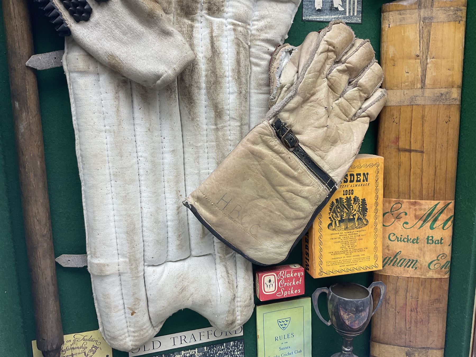 Four framed sporting memorabilia displays, the largest example containing 1930s cricket memorabilia, together with two fishing displays and a football display, each within wooden glazed frames, largest H105cm