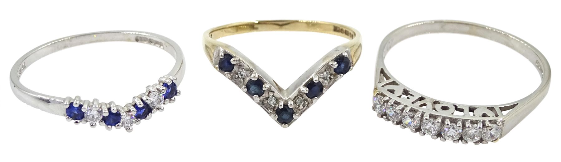 White gold seven stone cubic zirconia ring, with 'love' gallery, white gold cubic zirconia wishbone ring, both 14ct and a 9ct gold sapphire and diamond chip wishbone ring, all hallmarked 