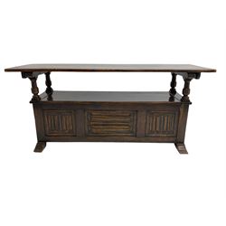 Jacobean design oak Monks bench, the front with carved linenfold panels, hinged metaphoric table back, hinged box seat compartment, on sledge feet