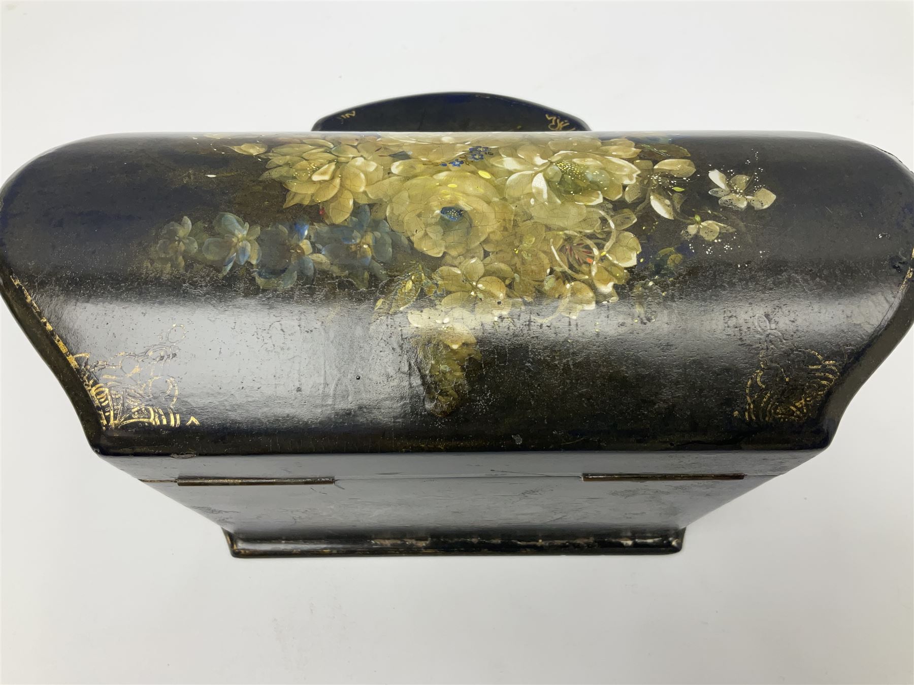 Victorian papier-mâché stationary box, of rounded wedge form with mother of pearl escutcheon, the hinged and curved cover and sides hand painted with floral sprays, opening to reveal a lined and fitted interior, H15cm L22cm D16cm