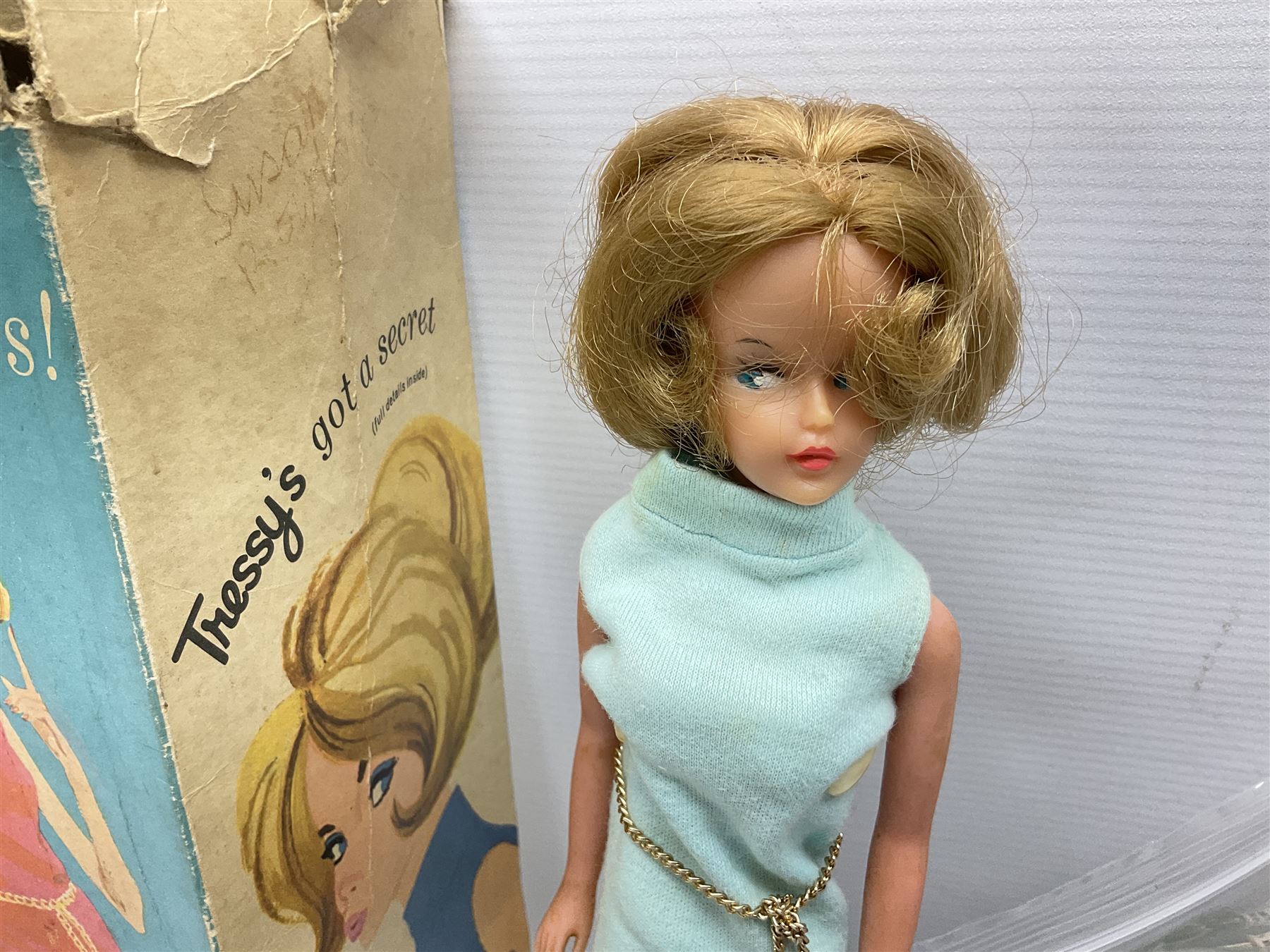 1960s Palitoy Tressy fashion doll, boxed with stand and booklets; four additional Tressy outfits (In The Office, Winter Journey, Winter Sports and Evening Date); two other outfits; and Tressy's Little Sister Toots doll with Style Book and additional outfit