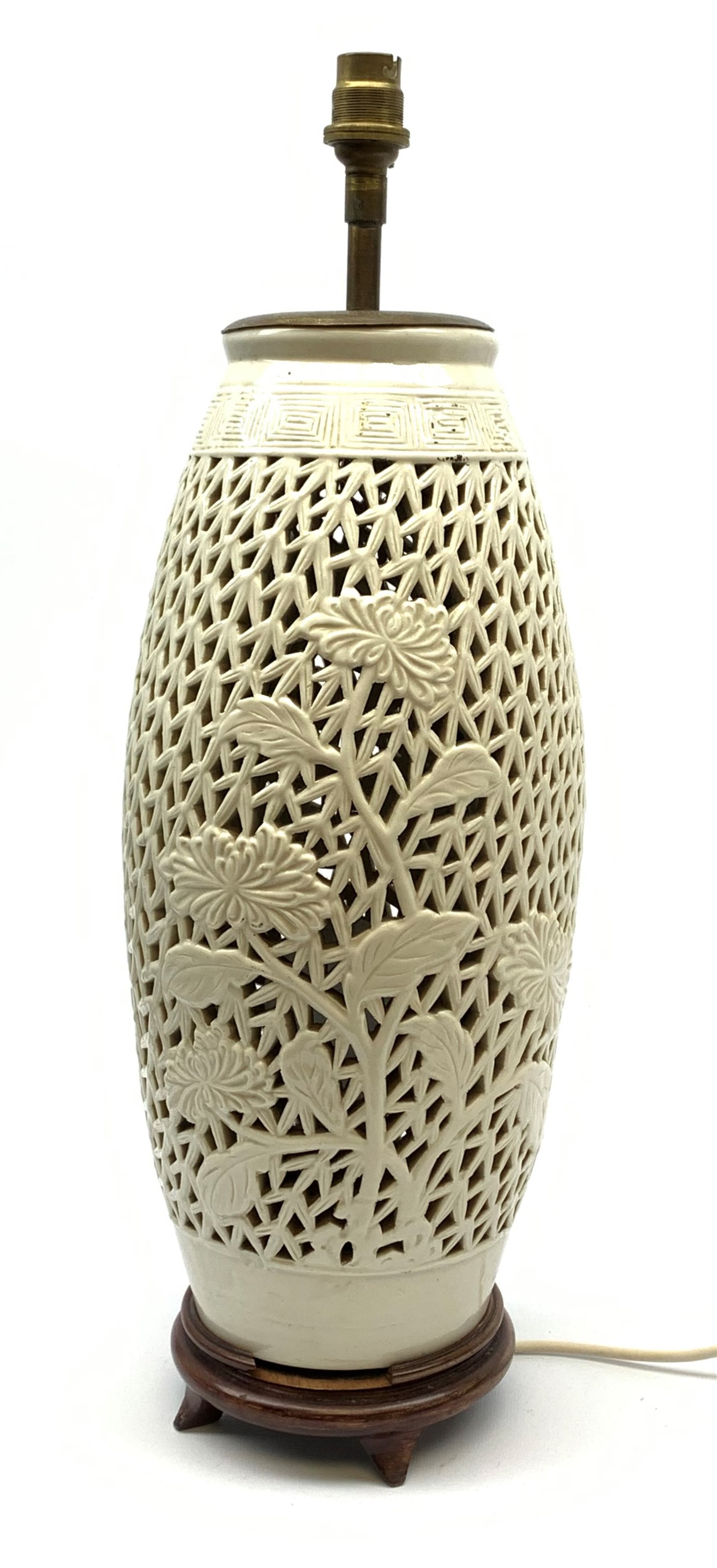 A Chinese reticulated or pierced white glazed lamp base on wooden