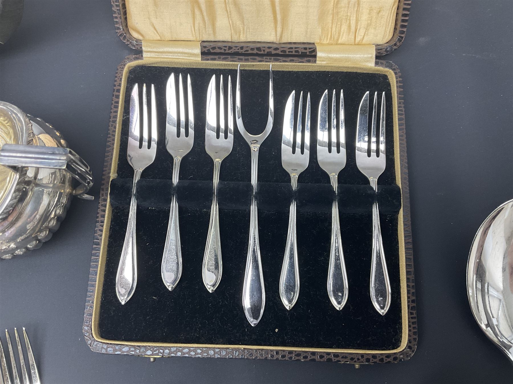 Mother of Pearl handled cutlery, with silver ferrules, comprising six fish knives and forks and six fruit knives and forks, the ferrules hallmarked Yates Brothers, Sheffield 1905, together with silver plated Edwardian three piece tea service and other flatware 