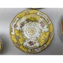 Five Coalport trios decorated in floral sprays with gilt in various colours, together with matching sugar bowl, dessert plate and saucer