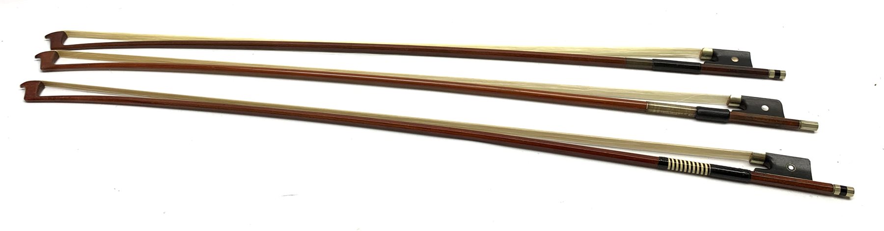 Three pernambuco bows by F.C. Pfretzschner with silver mounts, Adolf Thoma and Tourte