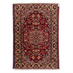 Central Persian Isfahan hand-knotted rug, madder red field, with elaborate central medalli...
