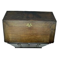 George III oak bureau, sloped fall-front enclosing a fitted interior with pigeonholes, small drawers, and a central compartment, over two short and two long drawers, brass escutcheons and drop handles, raised on bun feet