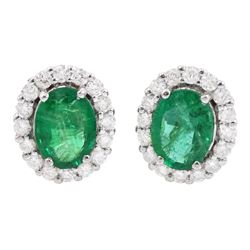 Pair of 18ct white gold oval cut emerald and round brilliant cut diamond stud earrings, stamped, total emerald weight approx 1.95 carat, total diamond weight approx 0.60 carat