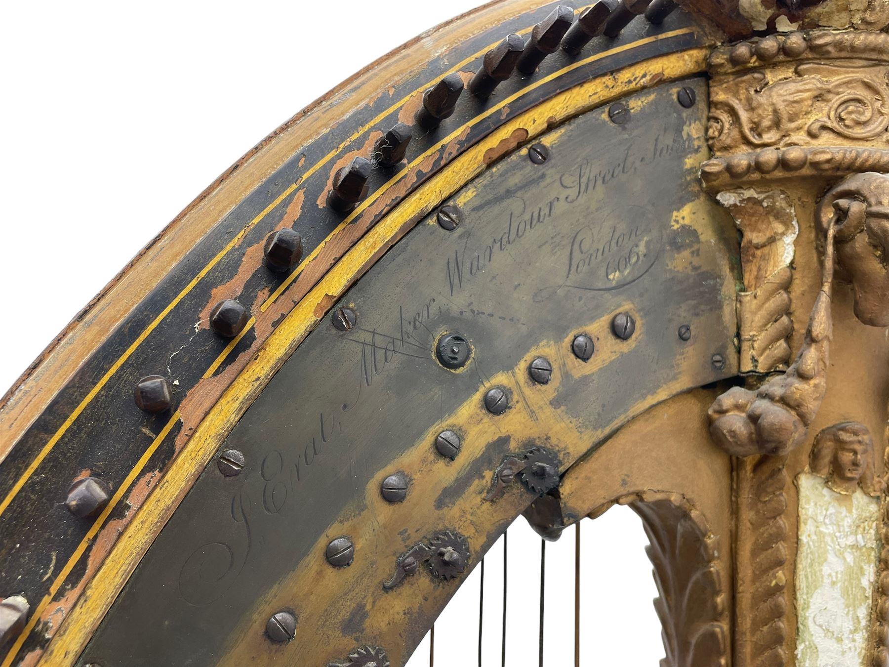 J. Erat. Wardour Street, London, Soho - Regency parcel-gilt and rosewood finish pedal harp, forty-three strings and five swell doors, the fluted pillar decorated with rams head capital, floral festoons, anthemion motifs and sarcophagi, the base decorated with pharaonic motifs and fitted with eight brass pedals, on carved paw feet, brass signature plate to top inscribed 'J. Erat. Wardour Street, London, Soho, 606'