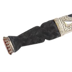 Skean dhu, the 9cm blade with scalloped back edge, with ebonised hilt and stone pommel, in its leather covered sheath with silver collar, hallmarked 1955