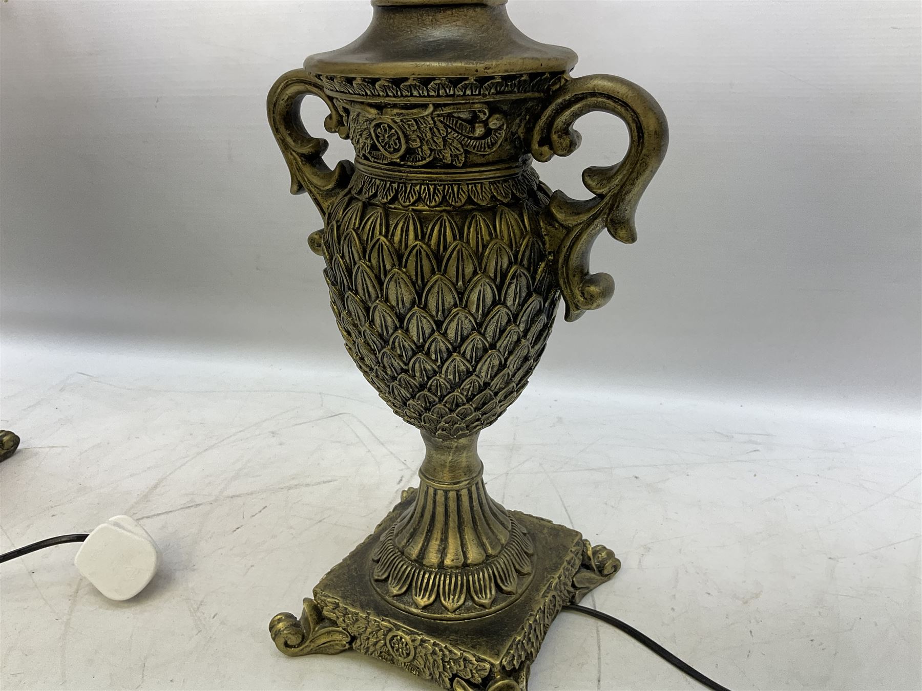 Pair bronzed amphora lamps with pineapple decoration, scroll handles and foliate base with scrolled feet together with pair peach ground shades and raised floral pattern H76cm (2)