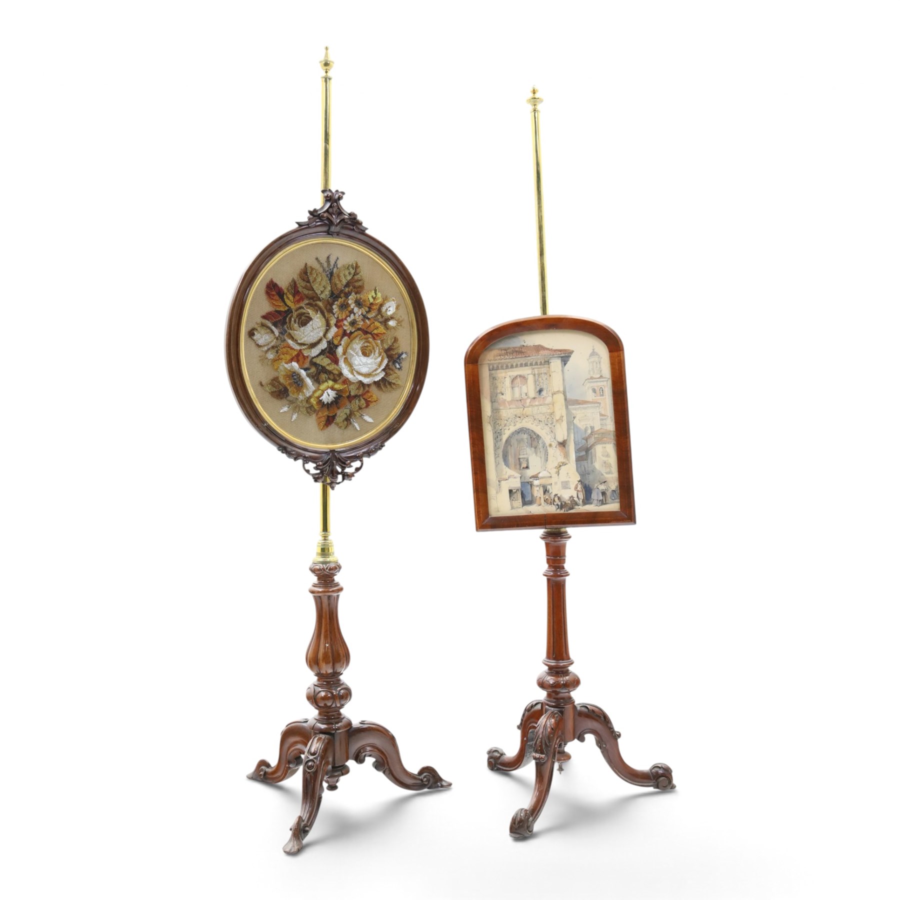 Two Victorian mahogany pole screens, comprising an oval example with floral needlework panel and carved cresting, on brass pole and tripod base with scroll carved supports (H 153cm, W 43cm, D 43cm); and a rectangular example with glazed architectural print panel, on brass pole, turned column and conforming scroll carved tripod base (H 147cm, W 38cm, D 38cm)
