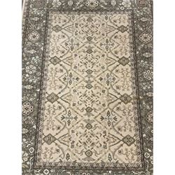 Persian design pale ground rug, decorated with interlacing branch and stylised flower head motifs, repeating floral design border