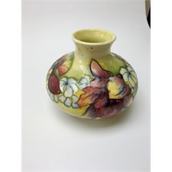 A Moorcroft vase, circa 1950, of squat bulbous form, decorated in the Orchid pattern upon a yellow glazed ground, with impressed and blue painted WM initials for Walter Moorcroft, H10.5cm. 