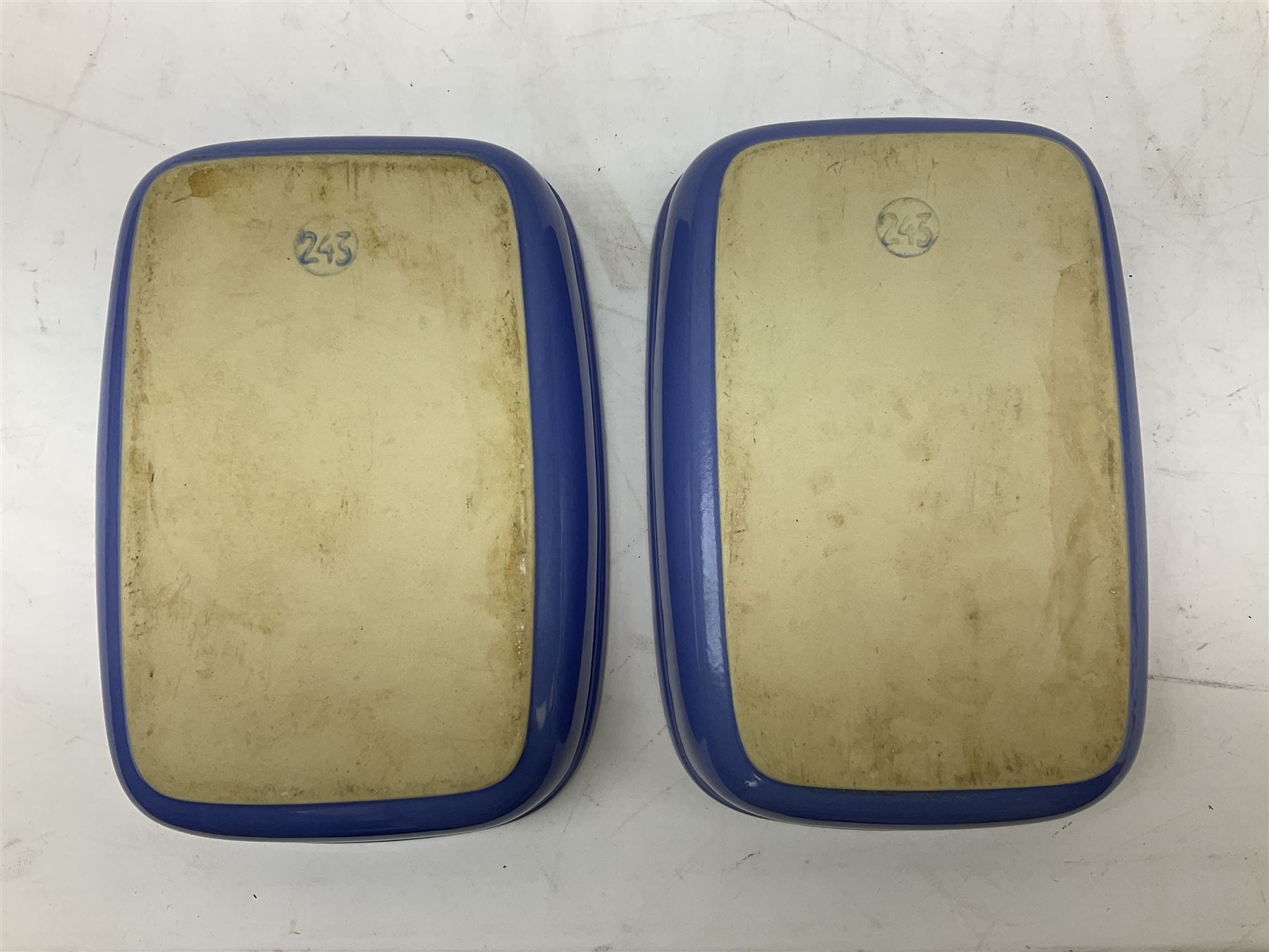 Emile Henry covered casserole dish of oval form in two tone brown and cream, no. 03.06, together with cast iron Nomar twin handled lidded casserole dish of oval form in navy, and other ovenware including Flintware ICTC, largest L35cm