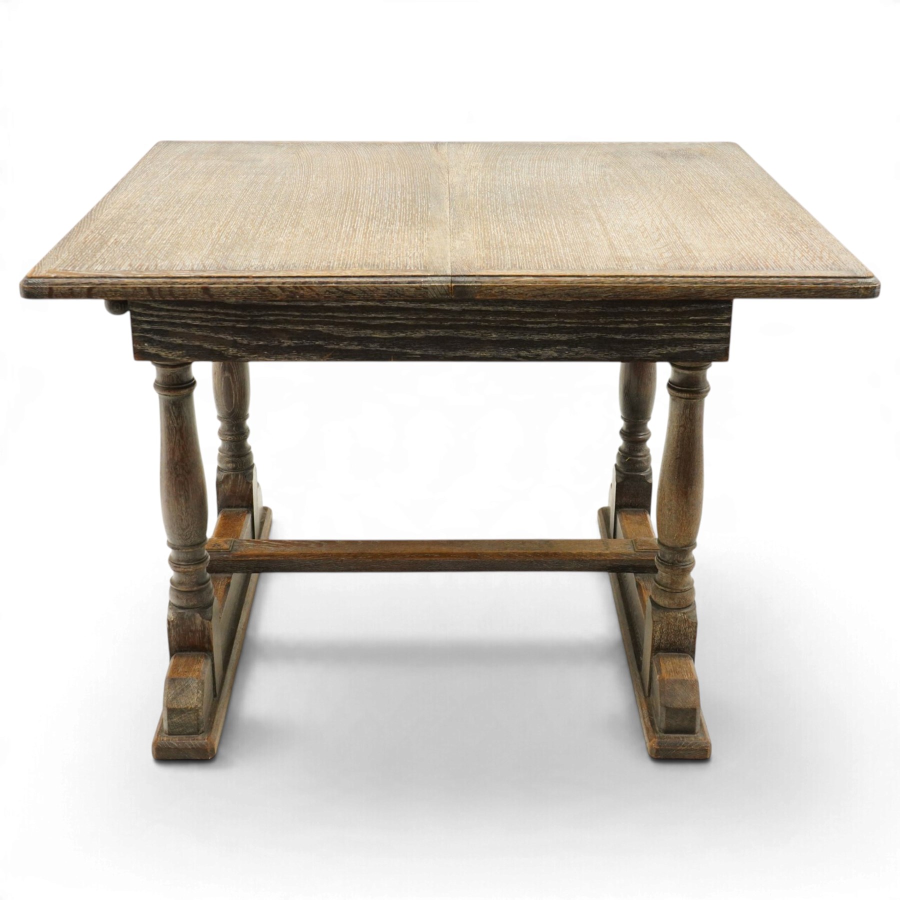 Arts & Crafts limed oak extending dining table, the rectangular draw-leaf top with integral leaf, raised on four turned supports united by H-stretcher; with set four matching lattice-back chairs on turned front-supports (W47cm H89cm)