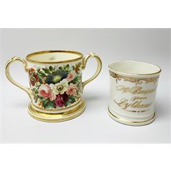 A 19th century Staffordshire documentary loving cup, inscribed in gilt to one side 'Presented to Mary Ann Wright Born August 29th 1862', and hand painted with flowers verso, H10cm, together with a smaller single handled example inscribed in gilt 'A Present from Lytham', H8.5cm. (2).