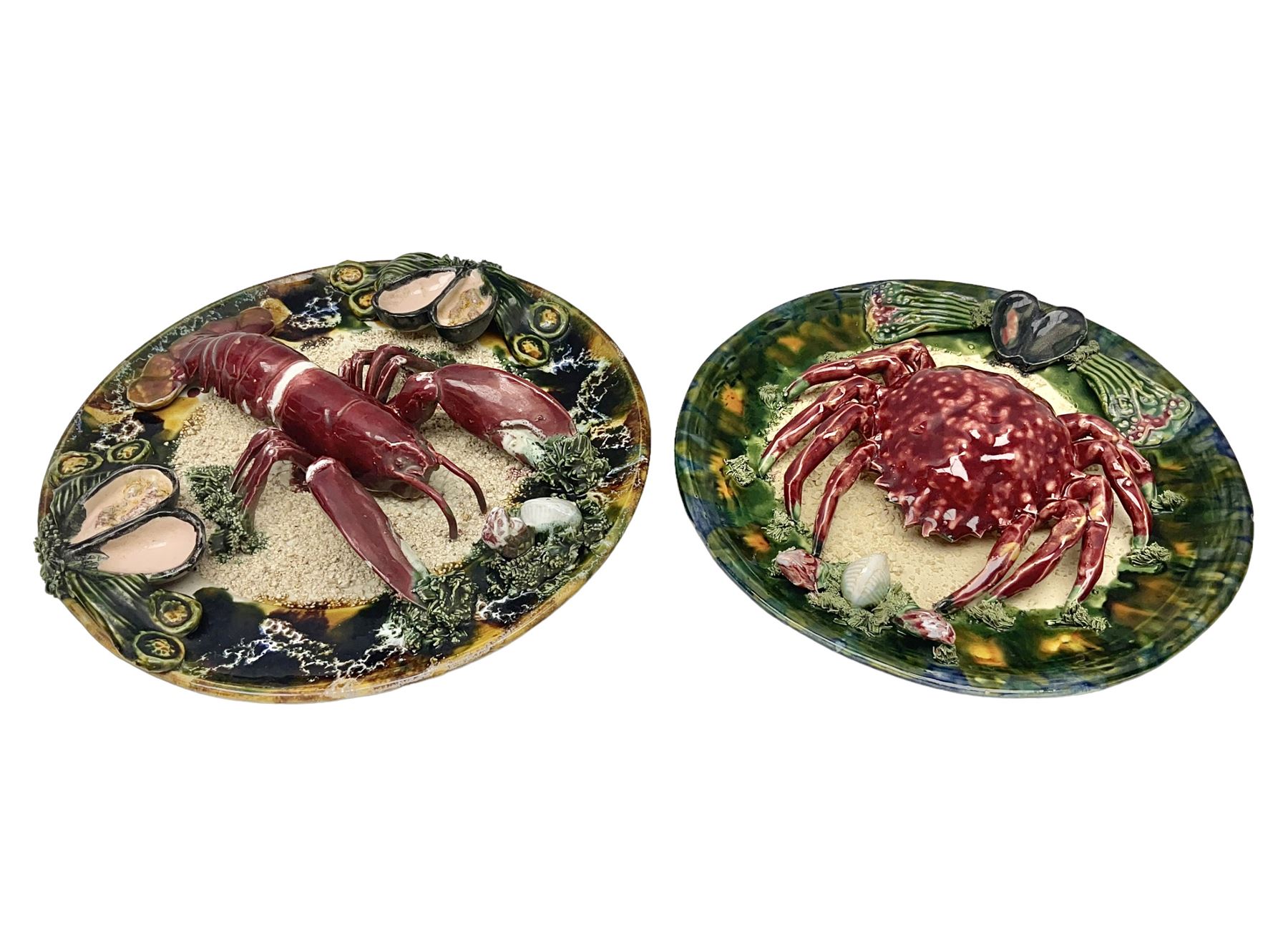 Two 20th Century Portuguese Palissy style Majolica wall plates, one depicting a crab, the other a lobster each to the centre modelled in relief surrounded by encrustations and shells, both with impress marks beneath, D32cm