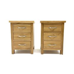 Pair light oak bedside pedestal chests, three short drawers, raised on stile supports 