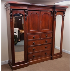  Victorian mahogany triple wardrobe, moulded projecting cornice, two full length mirrored wardrobe doors flanking two cupboard doors above two short and three graduating drawers, plinth base, W238cm, H211cm, D60cm  