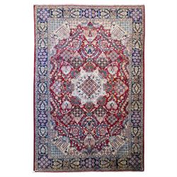 Central Persian Najafabad hand-knotted carpet, crimson field with a central elaborate cusp...