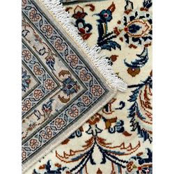 Persian Kashan ivory ground rug, decorated with curled leafy branches and palmettes, the border with scrolling design decorated with further palmettes, within floral pattern guard stripes