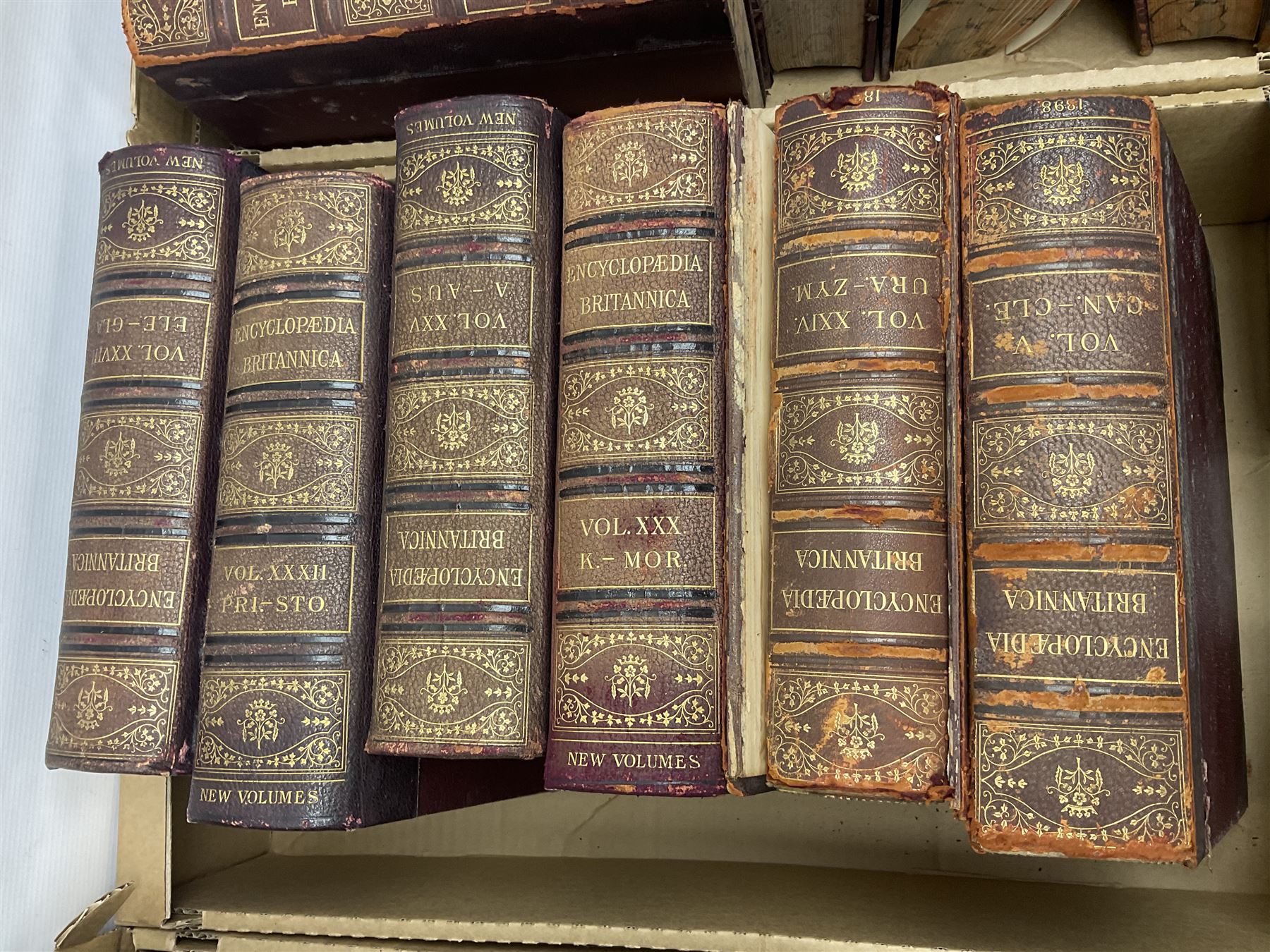 Thirty six volumes of Encyclopaedia Britannica with gold tooled red leather spines in various editions 