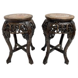 Pair of Chinese hardwood jardinière or urn stands, circular top with marble inset, the frieze carved and pierced with scrolling foliate decoration, raised on cabriole supports united by X-stretcher 
