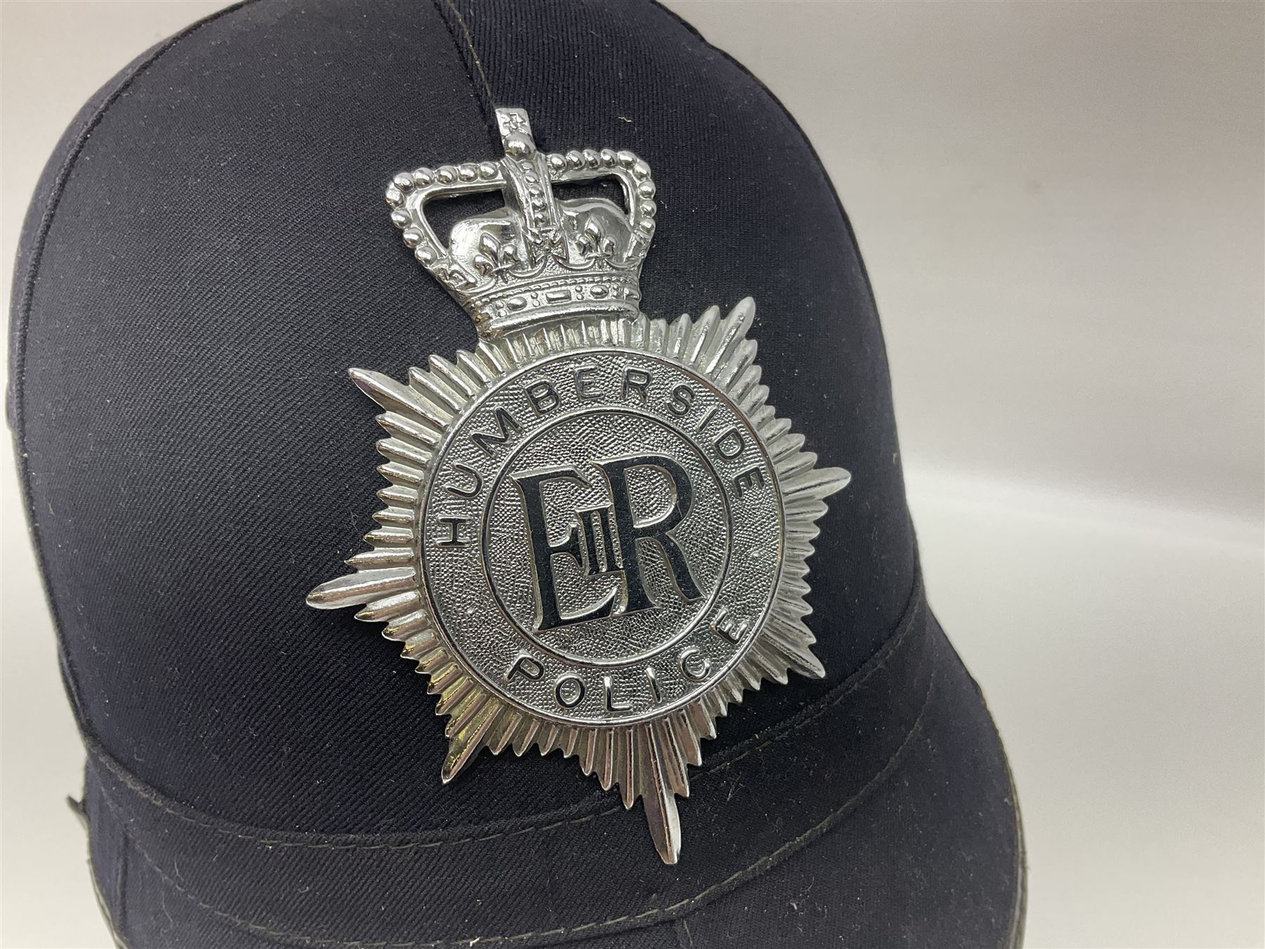 Police - Victorian turned hardwood truncheon with traces of decoration and VR cypher L42cm; Humberside Police helmet with Queens Crown helmet plate; hand lamp inscribed 'The Inspector'; and small pair of pewter figures of police officers (5)