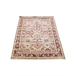 Large pale ground rug, decorated with stylised plant motifs, repeating border with scrolling design