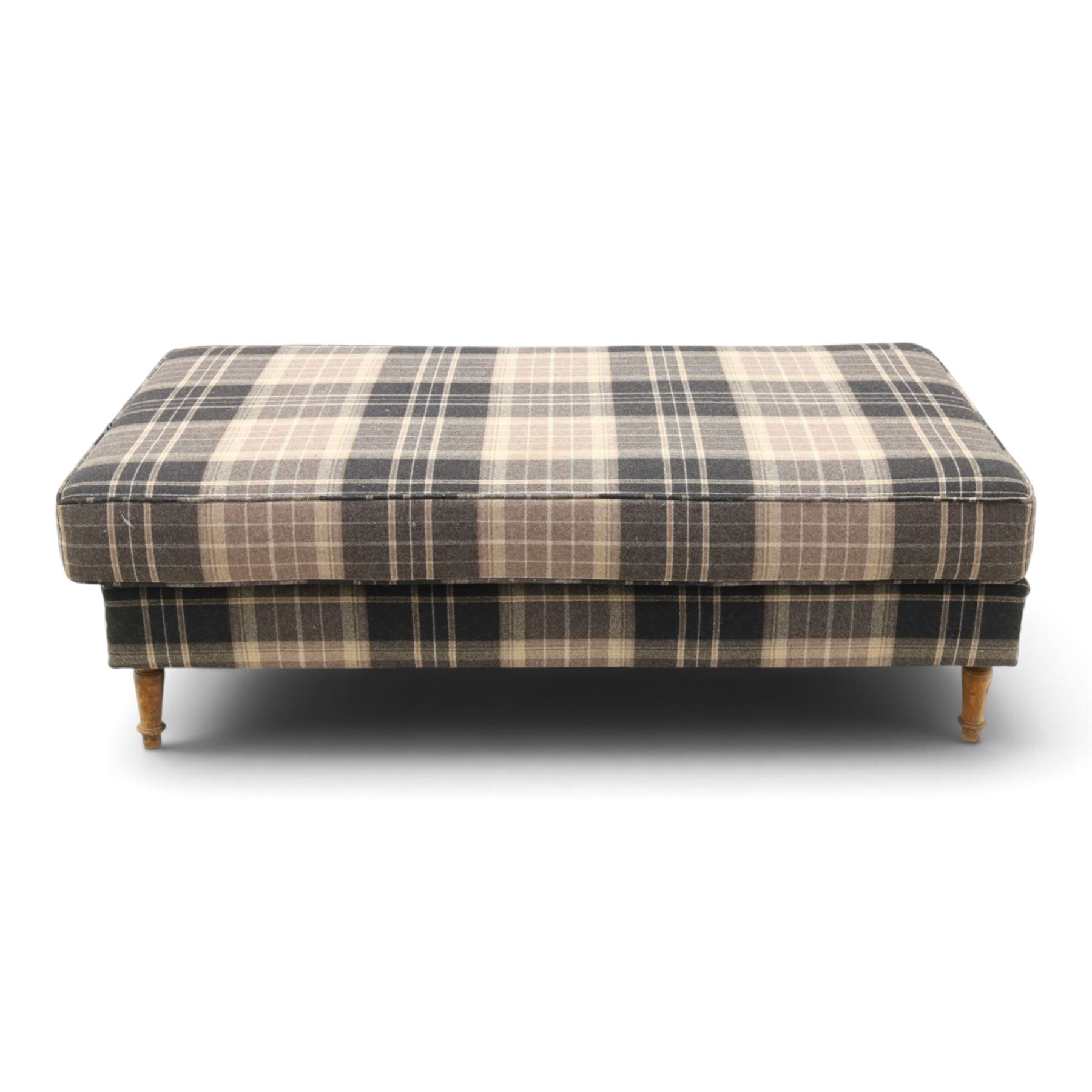 Large traditional design upholstered footstool, upholstered in checked fabric, with loose cushion, raised on a light turned supports 