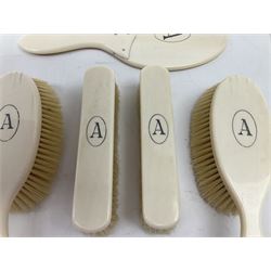 Early 20th century five piece ivory dressing table set, comprising handheld mirror, two hairbrushes and two clothes brushes, each initialled with the letter A. 