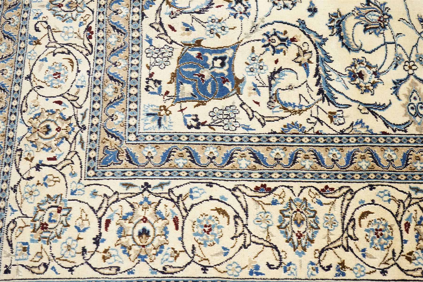 Central Persian Nain hand-knotted carpet, ivory field with central radiating medallion, issuing an all-over design of scrolling vines, palmettes, and delicate floral sprays with conforming spandrels, enclosed by a foliate border, framed by multiple guard stripes, with cotton fringe ends 