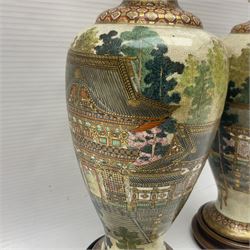 Pair of Japanese Satsuma vases, decorated with temple within a landscape, upon wooden stands, H22cm