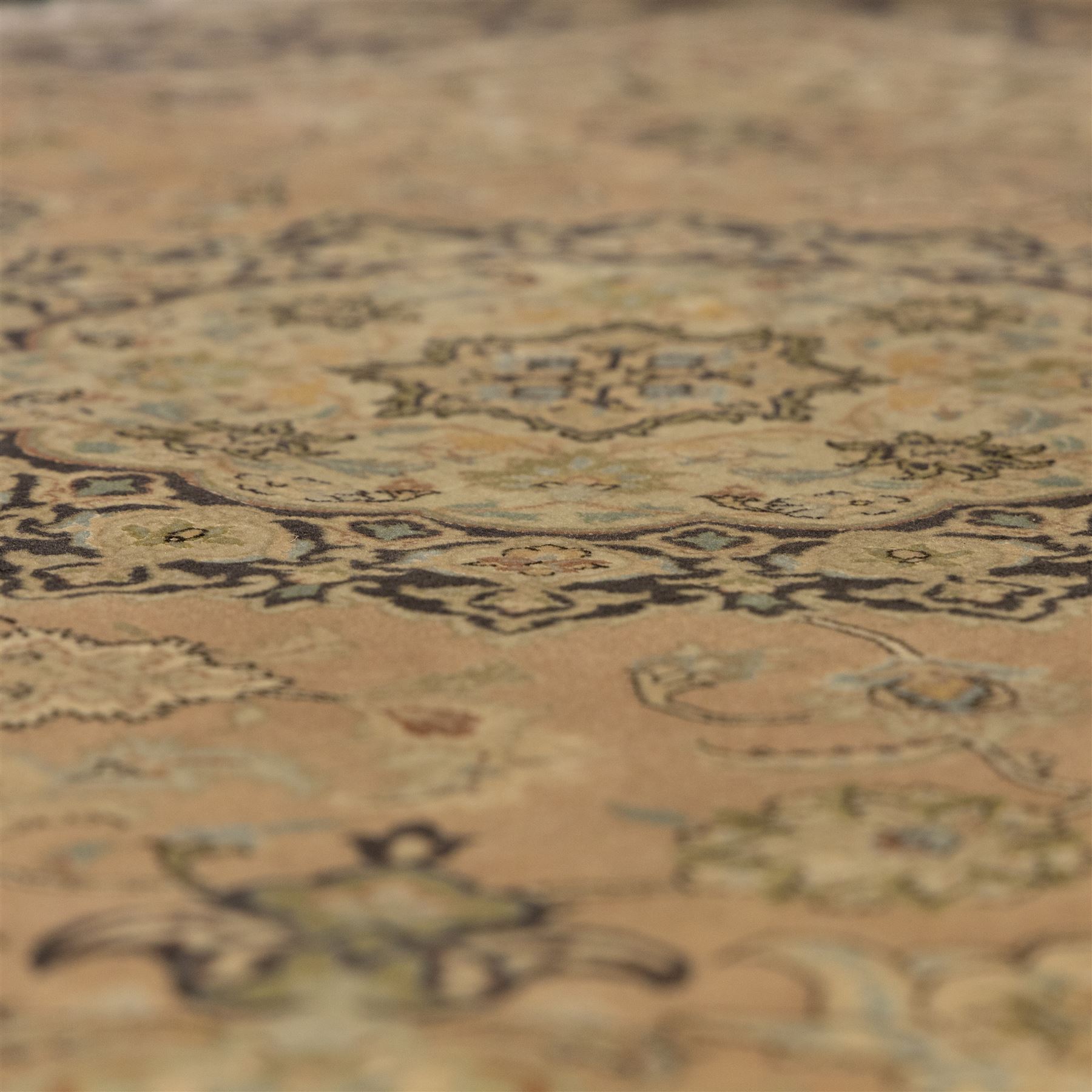 Persian Kashan style rug, salmon pink ground, central conforming lobed medallion in ivory and indigo, with palmette pendants, framed scrolling arabesques of lotus blossoms and palmettes, within navy border of meandering vines and flowerheads between ivory guard stripes 