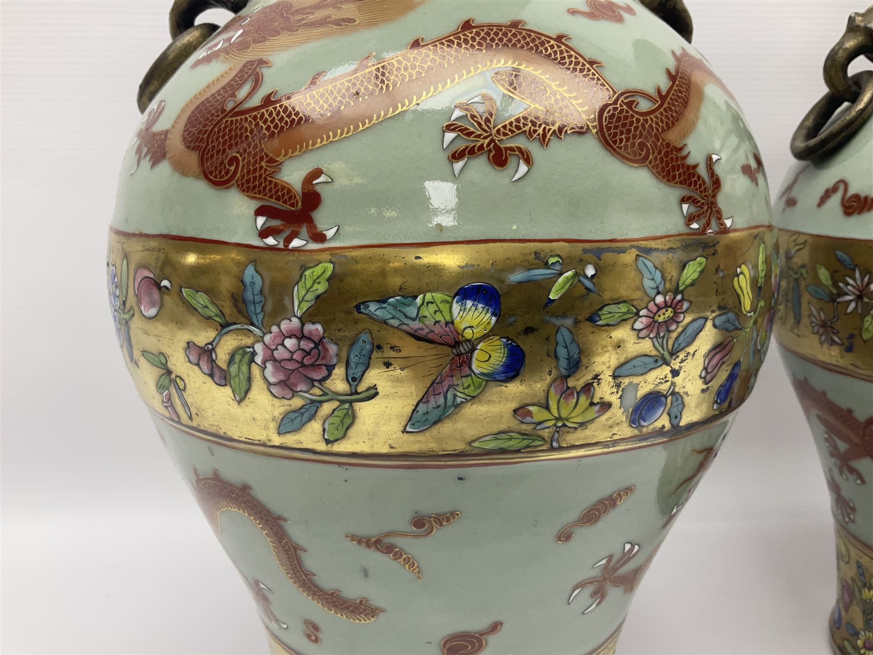 Pair of early 20th century Chinese vases decorated with dragons chasing a flaming pearl, with a gilt border of butterflies and floral sprigs, with Elephant head handles, H44cm 