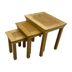 Contemporary light oak nest of three tables, each with rectangular top with moulded edge, raised on square supports