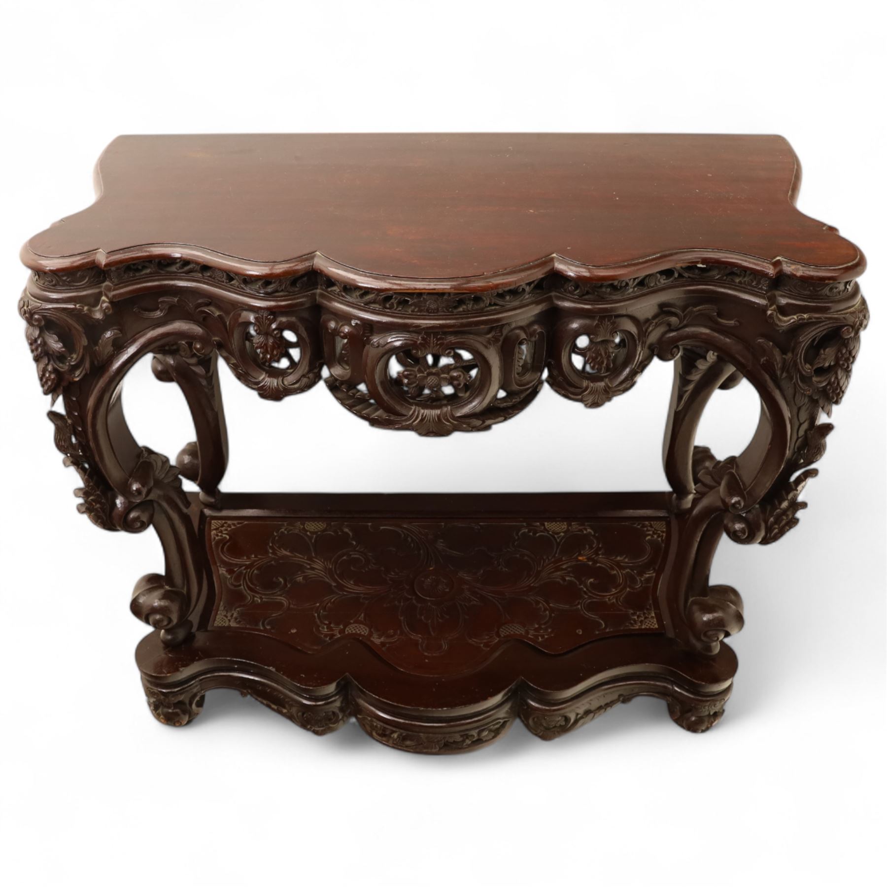 Chinese stained hardwood side table, late Qing dynasty style, with shaped top above a pierced and carved frieze of foliage and fruiting vines, cabriole legs terminating in scroll feet, united by a carved shaped undertier