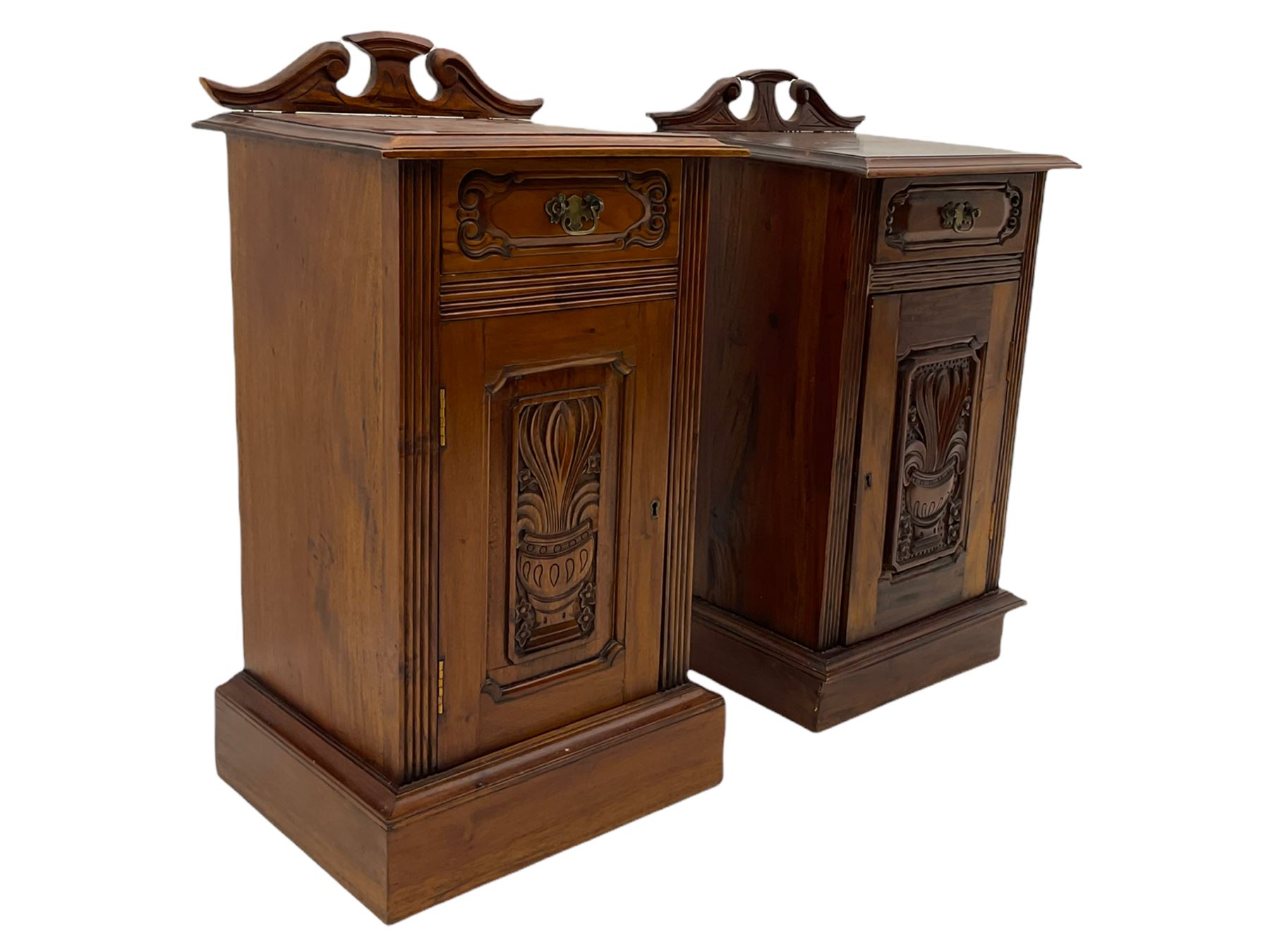 Pair Victorian style hardwood bedside cabinets, fitted with single drawer and cupboard, the doors carved with floral urns, on plinth bases
