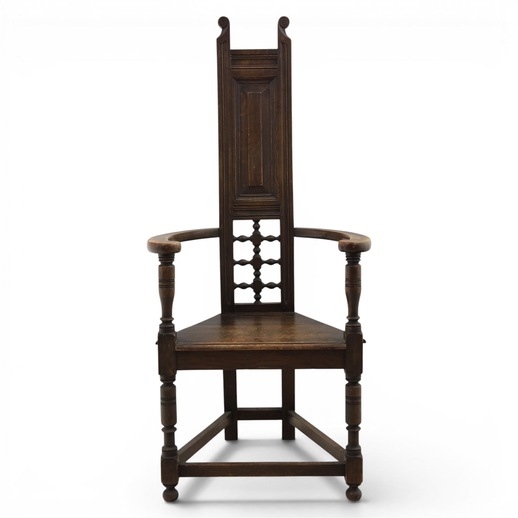 Manner of Liberty & Co. - Arts & Crafts oak Shakespeare chair, high back over triangular seat, flanked by swept arms, raised on turned and block supports united by stretchers