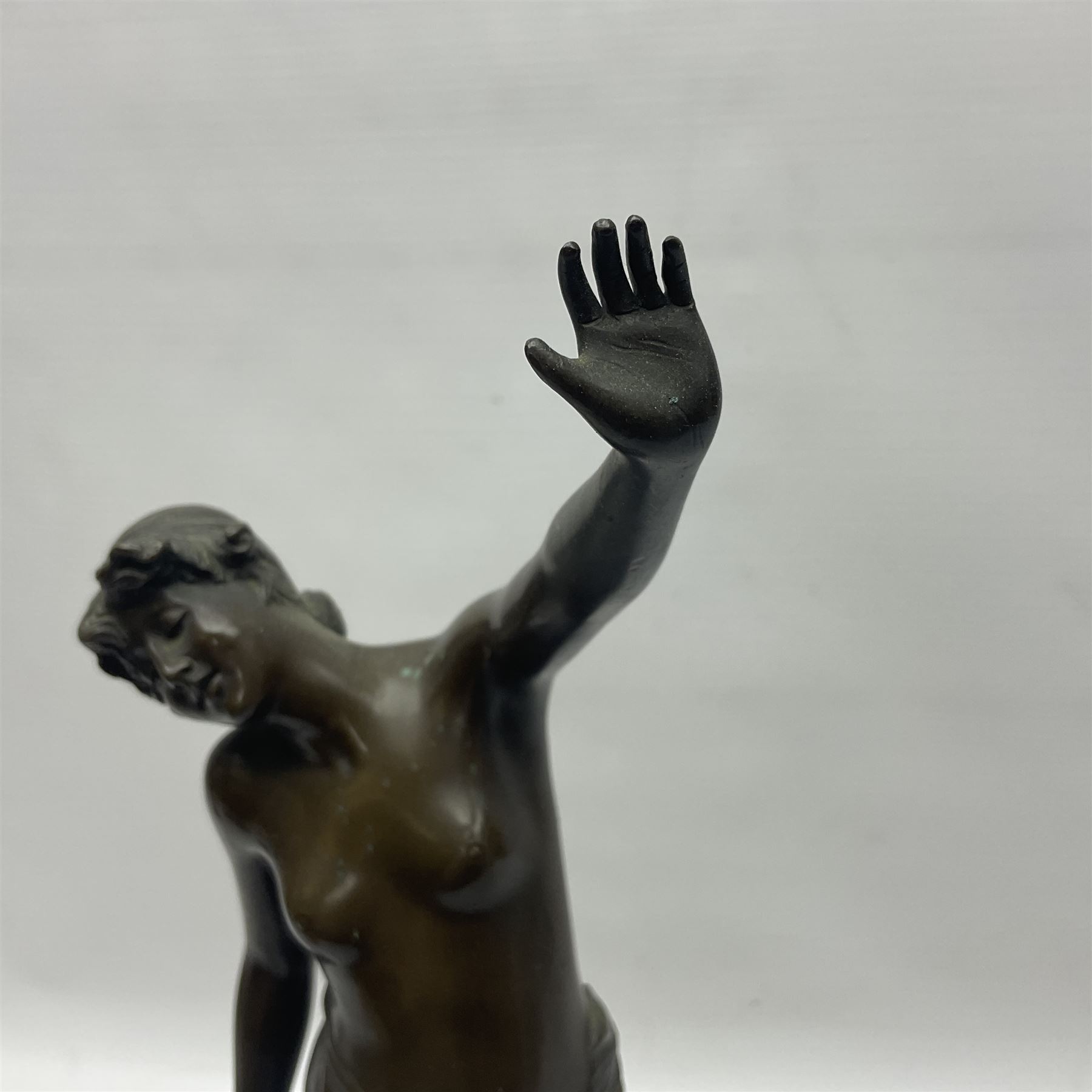 Bronzed semi nude female figure with one hand raised, upon a marble plinth, H43cm  